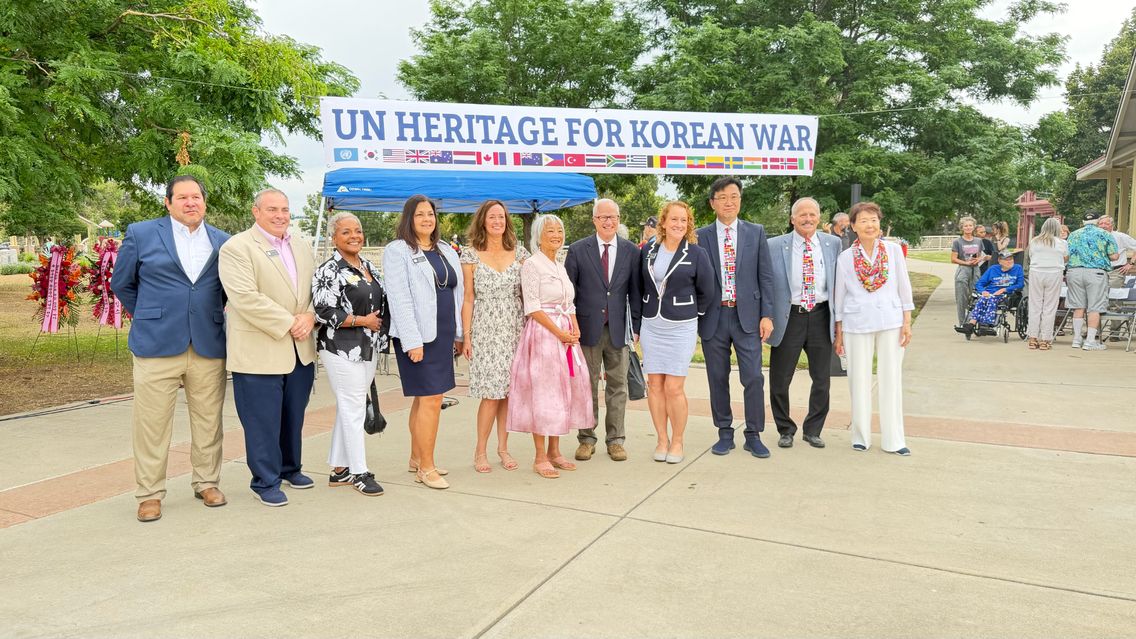 A group gathered beneath a banner reading UN Heritage for Korean War.